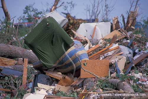 Piles of shredded furniture in a debris-ridden scene of tornado damage