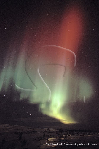 Red and green swirls of Aurora Borealis in an arctic landscape