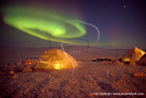 A swirling patch of Aurora and igloos with fire light inside