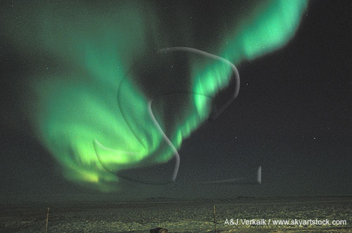 A whirling patch of green Aurora Borealis over arctic snow