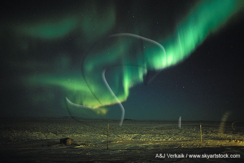 Whirling curtain of Aurora Borealis over arctic snow