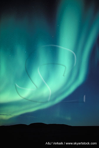 Laminar bands of blue-green Aurora Borealis over arctic hills