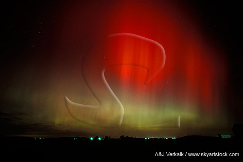 Streaky red and green northern lights) over farm lights