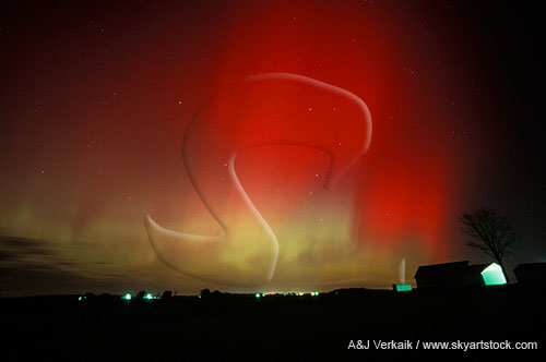 Awash with blood: patchy red Aurora Borealis spread over a farm