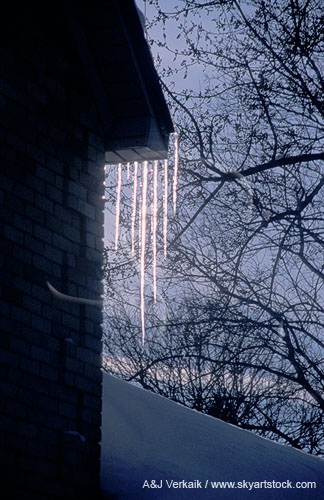 Glistening icicles hang from the eaves of a house