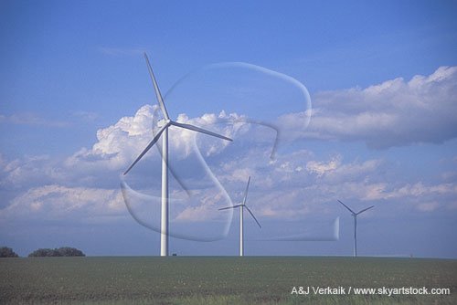 Three wind turbines in a wind farm with Cumulus clouds