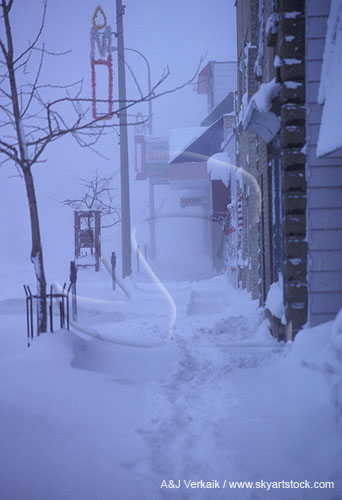 Scene of heavy snow on a town street and sidewalk