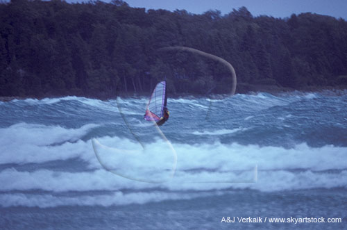 A windsurfer revels in wind and waves
