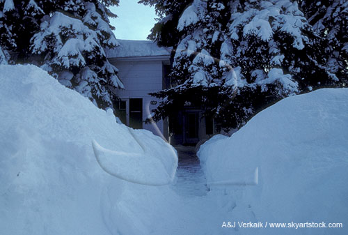 House hidden behind high snow after a winter storm