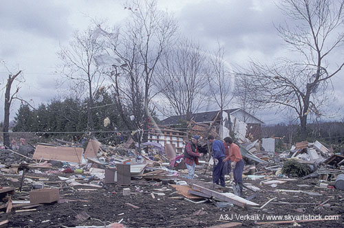 Neighbors searching for personal items to retrieve from a field of tornado debris