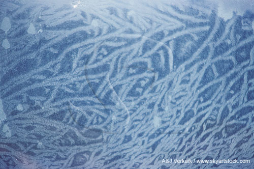 Feathery frost pattern on car window, close-up