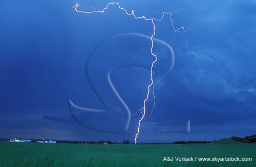 A single cloud-to-ground lightning bolt in full daylight is sharply etched