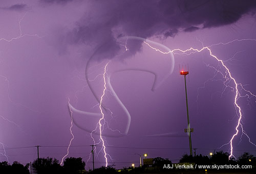 Cloud-to-ground lightning strikes around a tower