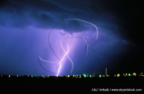 A single brilliant cloud-to-ground lightning strike over city lights