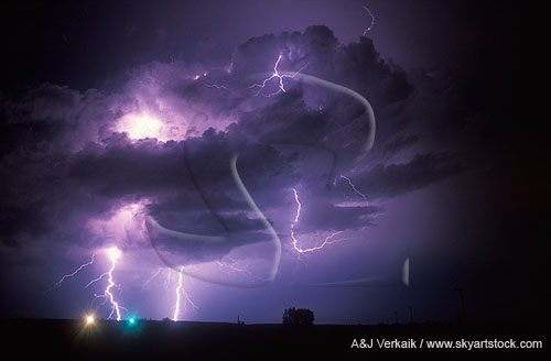 Lightning bolts and filaments peek out from low, dark clouds 