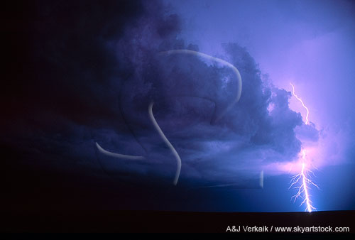 A highly electric power bolt strikes from a churning storm cloud
