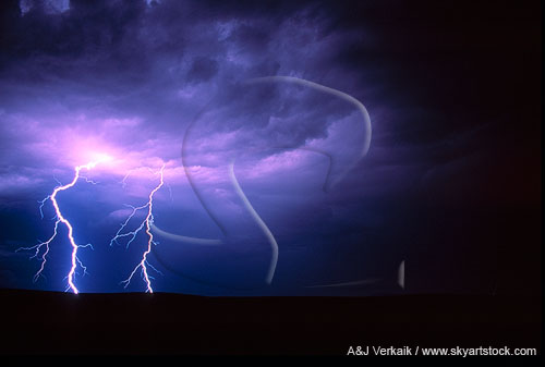 Brilliant cloud-to-ground lightning bolts light up the stormy sky