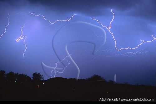 Horizontal lightning filaments run along the edge of a rain curtain