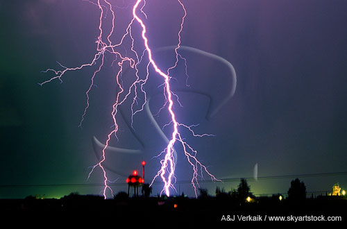 Close-up of white hot lightning strike with city lights