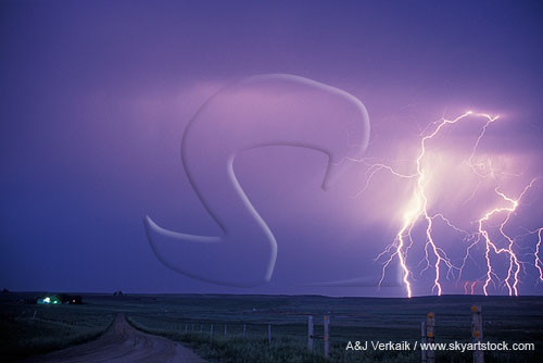 Brilliant lightning bolts approach a country road