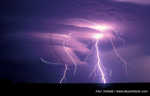 Highly electric forked lightning illuminates a laminar wall cloud
