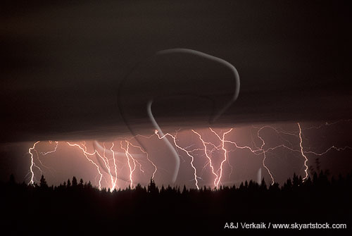 Multiple lightning bolts over a forest at night