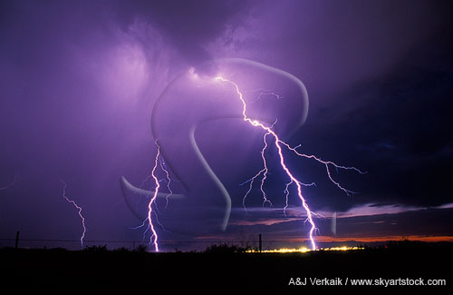 Brilliant forked lightning bolts strike a town at twilight