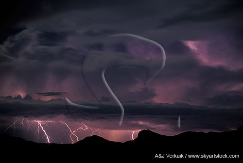 Distant lightning strikes illuminate a ghostly storm cloud