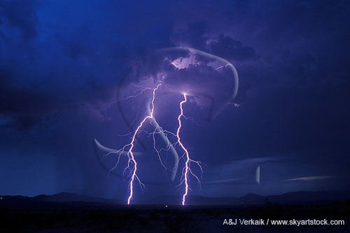 Two brilliant forked lightning bolts in a stormy sky at twilight