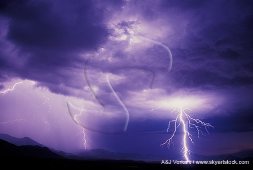 A remote landscape is struck by searing, electrifying lightning 
