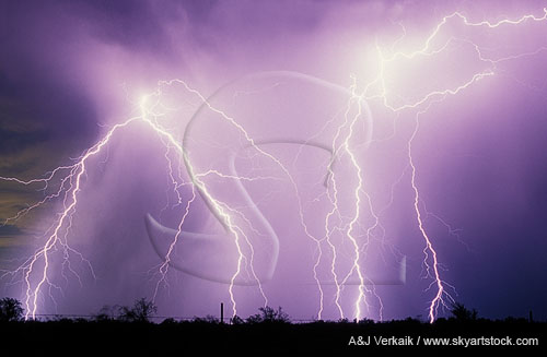Close-up of explosive lightning strikes within a brightened rainy area