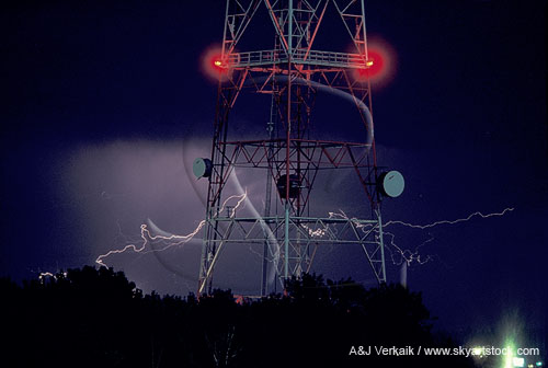 Lightning streamers behind a satellite communications tower