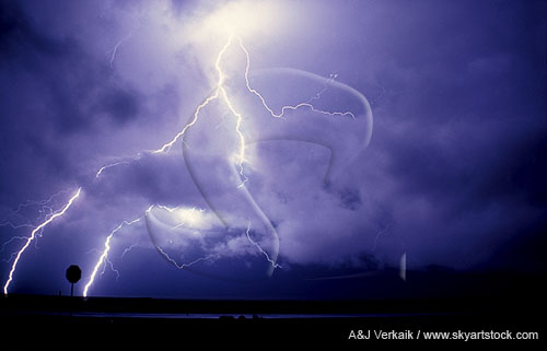 Brilliant cloud-to-ground lightning bolts strike through low clouds