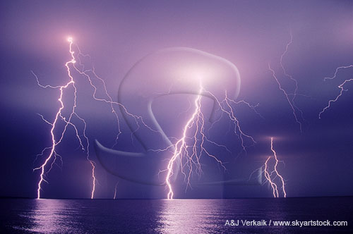 Close and distant lightning bolts over water