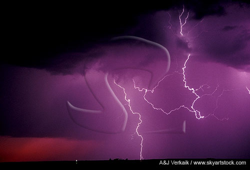Lightning bolt with long air discharge in a red and purple sunset