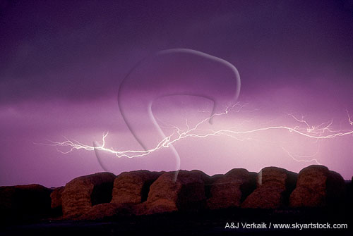 Horizontal lightning streamers over hay bales