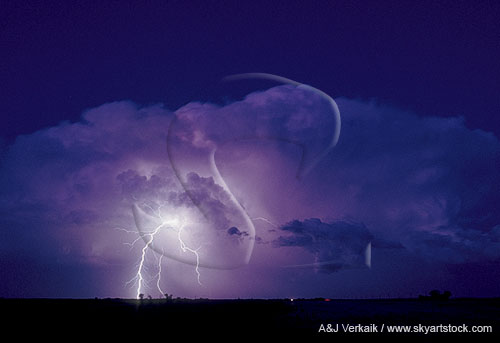 A Cumulonimbus storm cloud illuminated by a lightning strike