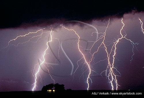 A tangle of highly electric lightning bolts over a farmhouse