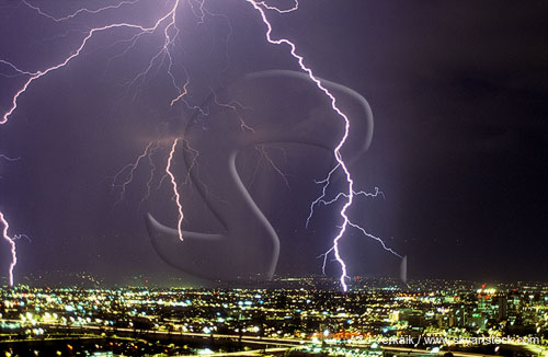 Close-up of jagged lightning over an expanse of city lights