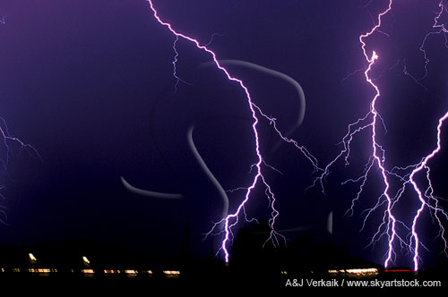 Brilliant knotted lightning discharges over city lights