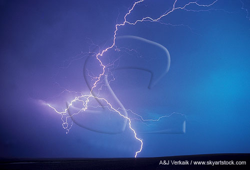 Rare looped and knotted lightning discharge in a deep turquoise sky 
