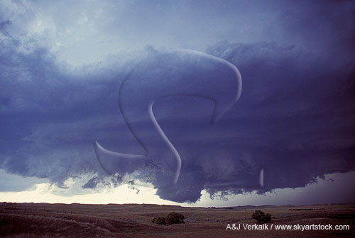 A prominent, rotating, backlit wall cloud