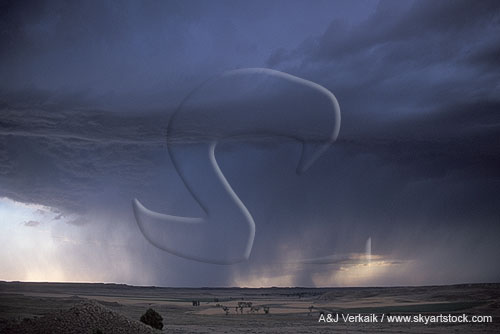 Dark cloud and sweeping rain advance over an arid landscape