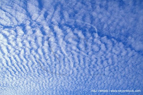Abstract of a ripple pattern with a thin clear blue slice of sky