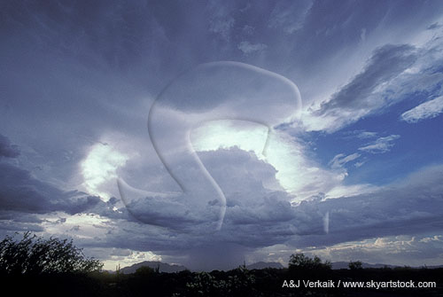 A surreal halo of silver lining light rings a mountain rain cloud