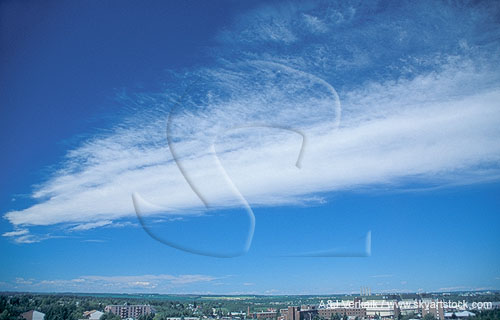 A streak of woolly cloud soars in a deep blue sky