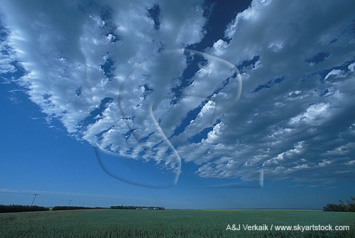 A sharply defined arc of cloud billows looks like a ship