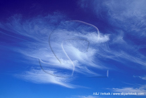 Wispy clouds race forward in a deep blue sky
