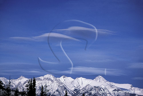 Two peculiar wave cloud patches, like spaceships over mountains