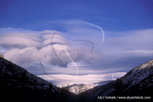 Standing wave clouds with rotor in mountains
